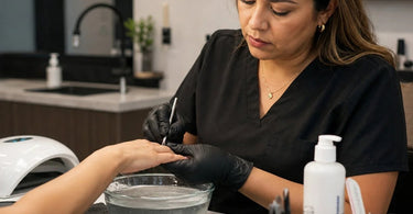 A serene image of a modern manicure bowl, a glass jar, and cuticle oil, symbolizing the blend of traditional soaking and modern nail care essential for professional manicure services.