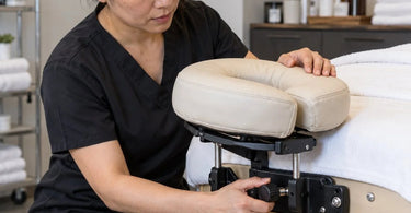 Professional massage table face cradle and adjustable headrest platform in a clean spa treatment room