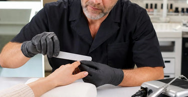 A professional nail technician meticulously refining a clients nail shape with a high-quality backup hand file, showcasing the precision and control needed for a flawless finish.