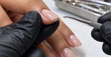 Close-up of a professional nail enhancement showing the underside of the free edge and the importance of removing excess gel or acrylic product buildup for a smooth finished manicure