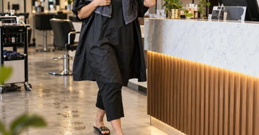 Professional hair salon floor near shampoo and styling stations illustrating how wet hair, water droplets, and loose clippings can create unexpected slipping hazards