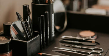 A comprehensive set of professional brow shaping tools including tweezers, scissors, brushes, and stencils.