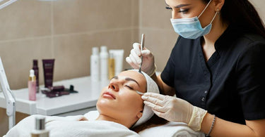 Esthetician performing dermaplaning on a client