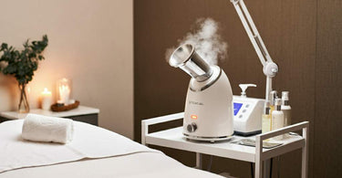 Esthetician using a facial steamer on a client in a spa setting