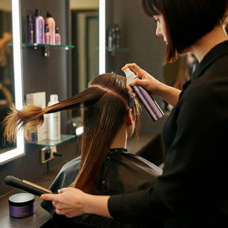 Professional hairstylist providing hair care treatment to a client in a salon