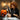 Esthetician humorously using an orange industrial shop vac on a client's face