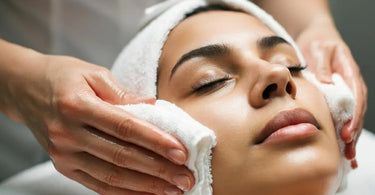 Hot towels being applied in a spa setting by an esthetician to relax and open skin pores