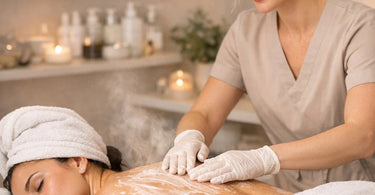 A relaxing spa treatment where an esthetician performs a back facial on a client, with organized product pairings nearby.