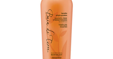 Bottle of Bain De Terre Keratin Phyto-Protein Sulfate-Free Strengthening Shampoo with lush botanical design