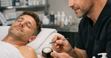 Close up of professional hands applying caffeine infused eye cream during a luxury spa facial treatment for brightening and depuffing.