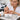 Close up of a professional nail technician applying a silk wrap to a natural nail for repair and strengthening
