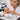 Close up of a professional nail technician applying a silk wrap to a natural nail for repair and strengthening
