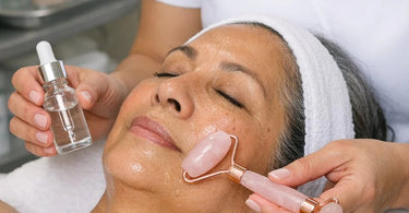 Close up of a Rose Quartz Roller being used on facial skin to demonstrate product penetration techniques for spa professionals.