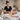Bottles of unscented hypoallergenic massage lotion and gel displayed on a wooden table with white linens, symbolizing safe and gentle oncology massage treatments.