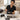 A nail technician cleaning an electric nail drill bit with a brush to maintain hygiene and sanitation in the salon.