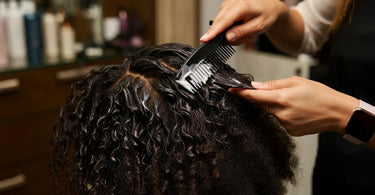 Professional stylist applying cholesterol conditioner treatment in a salon