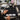 A collection of professional tint brushes of varying widths displayed on a color swatch, symbolizing the choice for roots, balayage, and full color services.