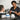 A professional barber applying a black neck strip to a client before a haircut, ensuring a clean and hygienic salon experience.