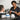 A professional barber applying a black neck strip to a client before a haircut, ensuring a clean and hygienic salon experience.