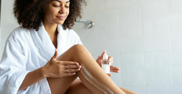 Coconut oil in a jar with coconuts in the background, symbolizing its use in post-waxing skincare.