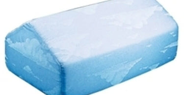 Grey Core Products Knee Elevator foam wedge, 7 by 10 by 17 inches, shown on a table to illustrate proper client positioning for massage and spa treatments