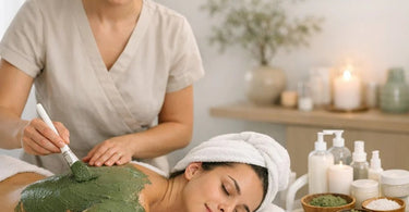 A serene spa treatment room setup showing a comfortable massage table draped with linen, ready for a detoxifying body wrap treatment, with bowls of natural ingredients like clay and seaweed nearby.