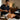 Mobile massage therapist preparing sensory ritual supplies with aromatherapy oils and portable equipment in a client's living room.