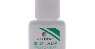 Close-up of Cuccio Pro Brush & Dip Brush-On Glue bottle with applicator brush, isolated on a clean background.