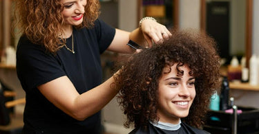 Salon professional working with a client with curly hair