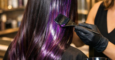 A hairstylist's hands mixing custom hair gloss colors in a salon bowl, showcasing vibrant direct dyes and tools.