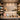 A beautifully styled front desk retail impulse buy zone featuring a curated selection of small spa products, including cuticle oil, sugar scrubs, and aromatherapy oils, arranged on elegant trays with soft lighting to encourage spontaneous purchases.