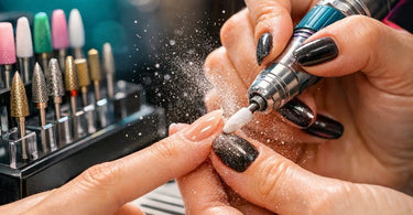 A collection of various professional e-file bits for nail drills, showcasing different shapes, materials, and color-coded grits, laid out on a clean surface, representing a comprehensive guide for nail technicians on cuticle care and safe usage.