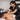 Massage therapist demonstrating proper ergonomic lunge stance and low table height while performing deep tissue work on a tall client