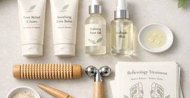 A collection of foot reflexology retail products including a soothing foot balm, calming foot oil, refreshing mist, and a wooden foot roller, arranged on a soft surface.