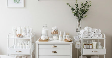 Spa treatment room stocked with professional supplies including cotton rounds, waxing tools, massage oils, and rolling carts