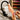 Nail technician practicing on a training hand with colorful gel polishes and nail art tools