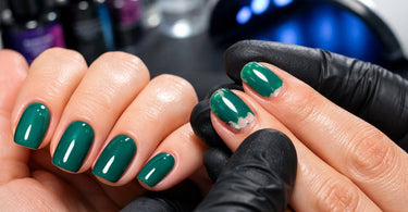 A close-up image of a woman's hand showing a gel manicure with visible lifting at the cuticle and tip, illustrating common gel polish problems for a troubleshooting blog post.