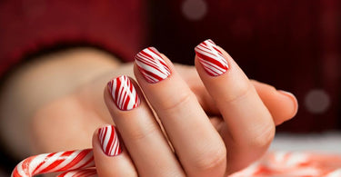 Festive holiday manicure with candy cane stripes and Santa hat designs