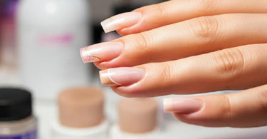 A variety of healthy nail enhancements including soft gel, dip powder, and acrylics on a spa table