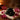 A professional spa therapist performing a hot stone massage with smooth basalt stones on a client's back in a serene spa environment