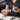Professional nail technician filing an almond-shaped nail on a client to achieve perfect symmetry at the salon station