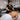 A comprehensive and efficient back facial setup featuring a professional massage table, a fully-stocked spa cart, and a facial steamer.