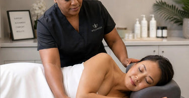 Spa professional adjusting a contoured cervical pillow for a side-lying client on a massage table for optimal comfort and alignment.