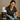 Professional massage therapist cleaning a portable massage table with disinfectant spray and microfiber cloth
