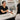 A smiling esthetician waves goodbye to a happy client in a serene spa setting