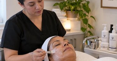 Spa professional providing a relaxing treatment to a quiet client in a calm treatment room with warm lighting and professional equipment