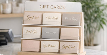 A stylish spa gift card display featuring cards with messages like 'Gift Card' and 'Spa Retreat' alongside decorative elements like a candle and stones to create an inviting sales presentation.