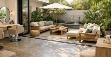 A serene salon space with large glass doors open to a lush outdoor patio, featuring a massage table and stylish decor for seamless indoor-outdoor flow.