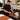 A spa professional demonstrating a seasonal spa service enhancement with aromatherapy oils, towels, and treatment products.