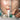 Esthetician applying a rich repair cream to a client's face during a facial treatment in a spa